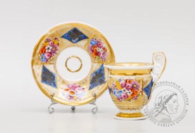 Фарфоровая чайная пара, украшенная чередующимися изображениями цветов и военной арматуры